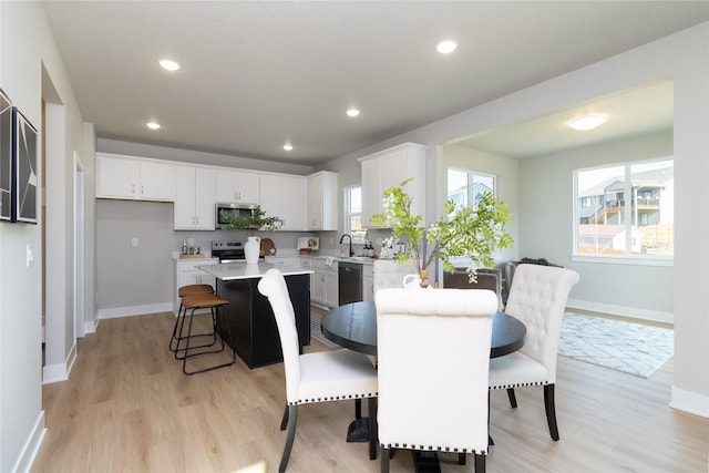 dining area featuring sink and light hardwood / wood-style flooring