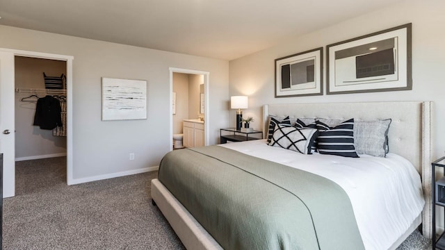 carpeted bedroom featuring a closet, ensuite bath, and a walk in closet