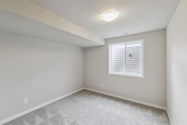 spare room with a textured ceiling and carpet