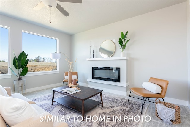 living room featuring carpet flooring, ceiling fan, and a textured ceiling