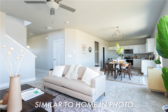 carpeted living room featuring a textured ceiling, ceiling fan, and sink