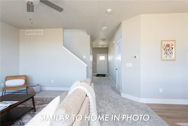 interior space featuring a textured ceiling, light hardwood / wood-style flooring, and ceiling fan