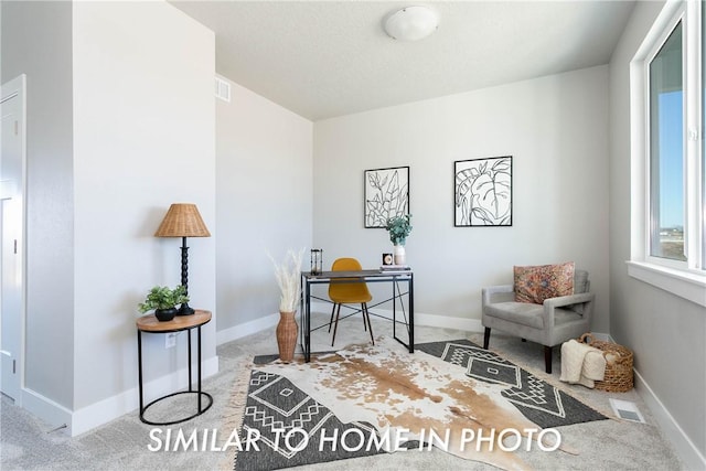 office space featuring light carpet, visible vents, and baseboards