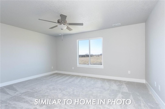 spare room with a textured ceiling, carpet flooring, visible vents, and baseboards