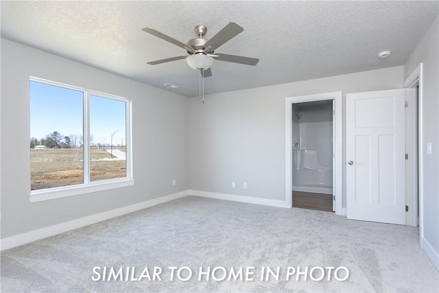 unfurnished bedroom with light carpet, a textured ceiling, ensuite bathroom, and baseboards