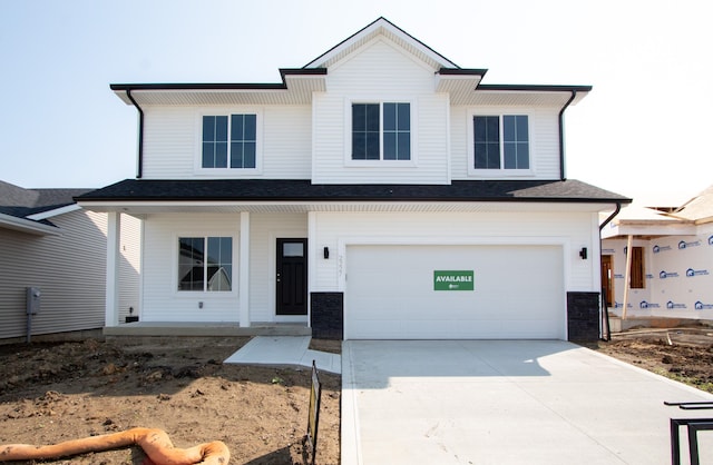 modern farmhouse featuring concrete driveway, covered porch, and an attached garage