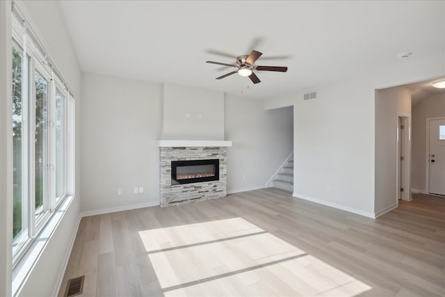 unfurnished living room with light hardwood / wood-style floors, ceiling fan, and a fireplace