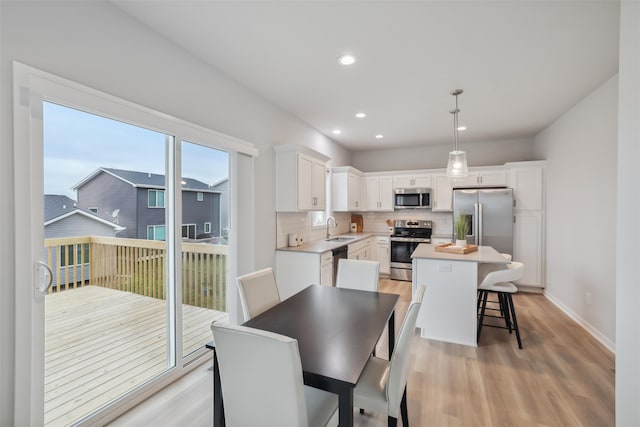 dining area with light hardwood / wood-style flooring and sink