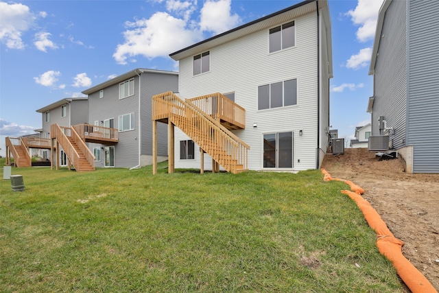 rear view of house with a wooden deck, a yard, and central AC unit