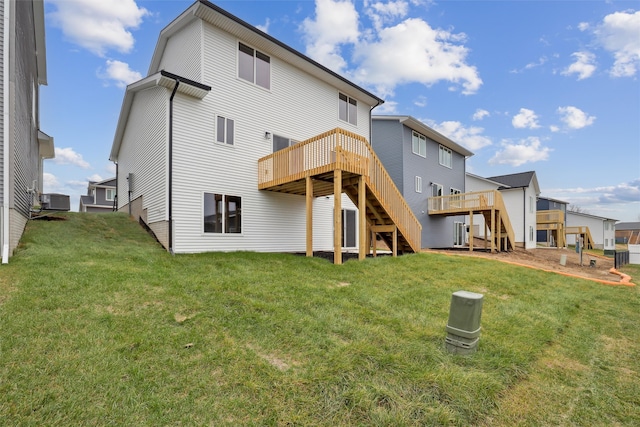 back of property with a yard, central AC unit, and a deck