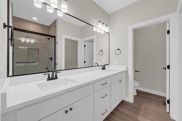 bathroom with walk in shower, vanity, wood-type flooring, and toilet