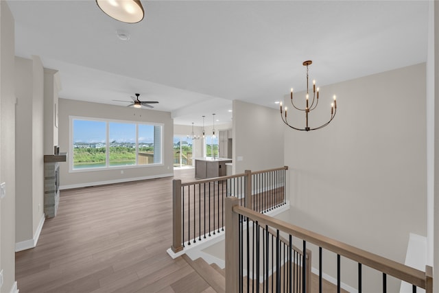 corridor with a chandelier and light hardwood / wood-style floors