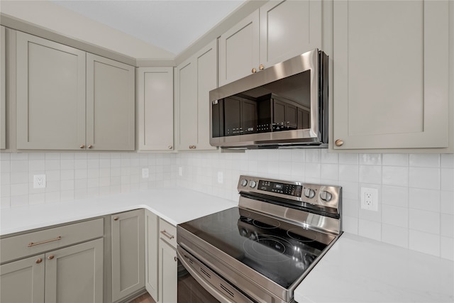 kitchen with gray cabinets, decorative backsplash, and stainless steel appliances