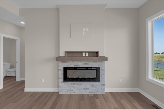 unfurnished living room featuring light hardwood / wood-style floors and a brick fireplace