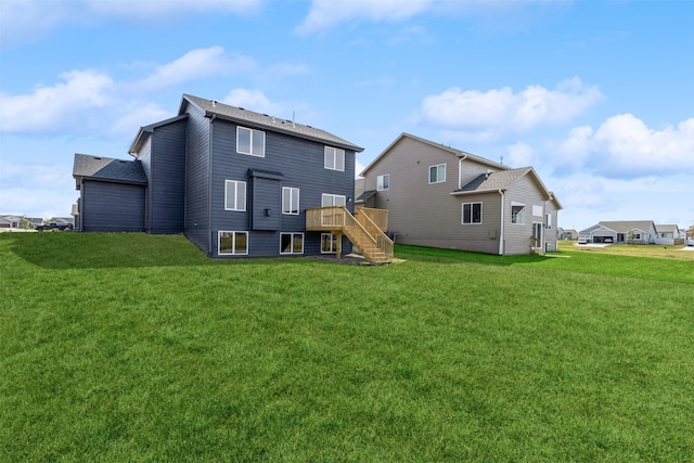 rear view of property featuring a deck and a yard