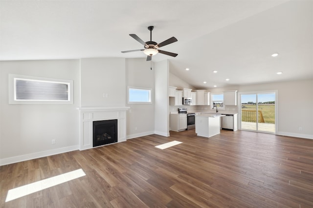 unfurnished living room with vaulted ceiling, ceiling fan, and hardwood / wood-style flooring