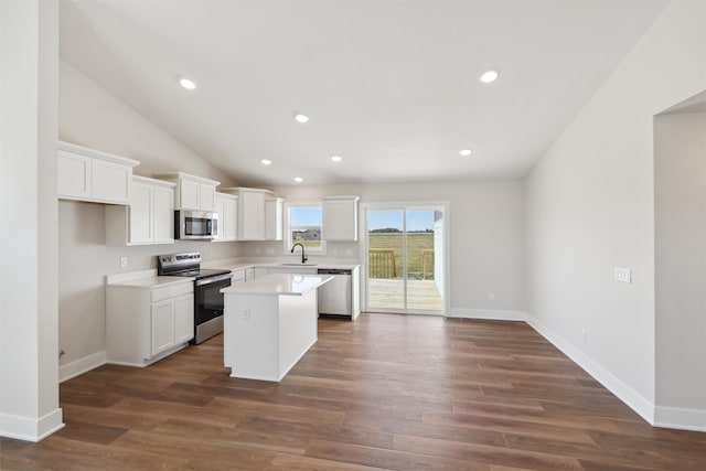 kitchen featuring stainless steel appliances, dark wood-type flooring, white cabinetry, and a kitchen island