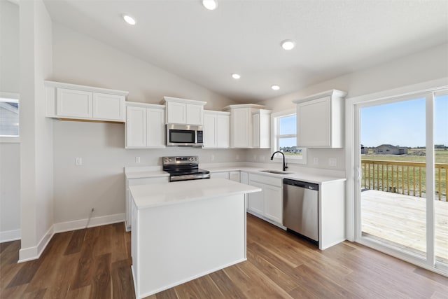 kitchen featuring lofted ceiling, white cabinetry, appliances with stainless steel finishes, and sink