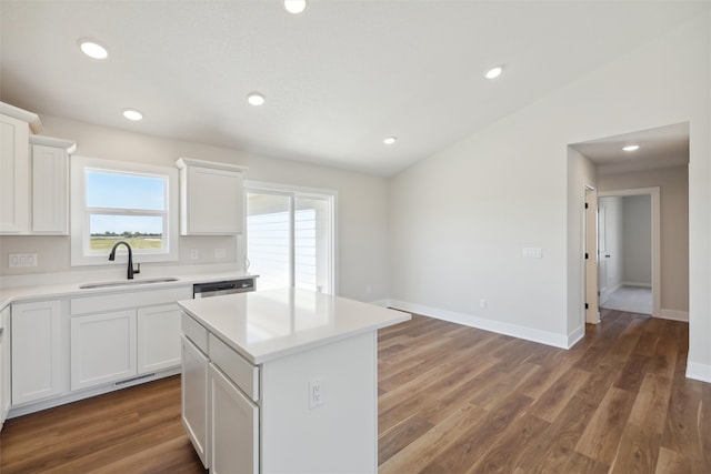 kitchen with white cabinets, a center island, dark wood-type flooring, and sink