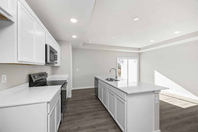 kitchen with stainless steel appliances, a center island with sink, sink, and dark wood-type flooring