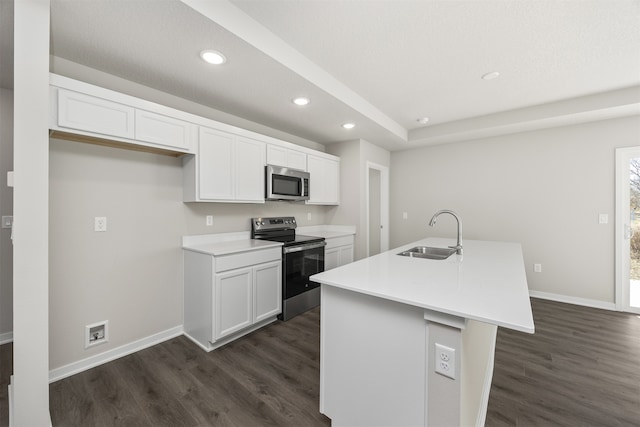 kitchen featuring appliances with stainless steel finishes, dark hardwood / wood-style floors, sink, an island with sink, and white cabinets