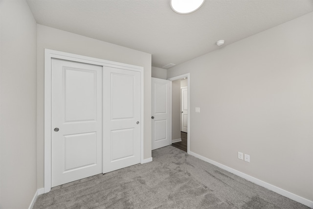 unfurnished bedroom with a closet and light carpet