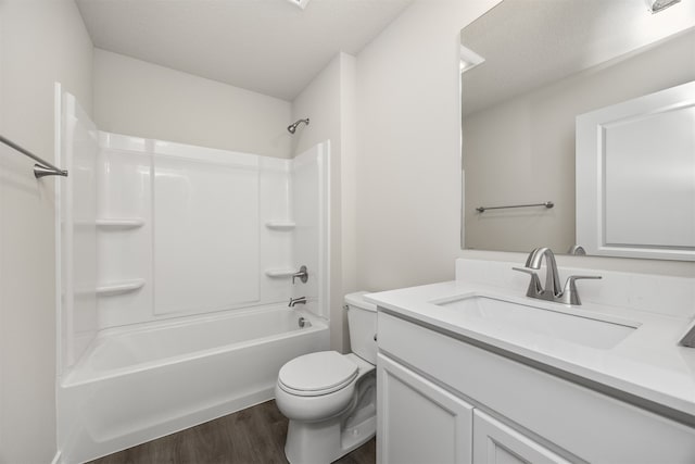 full bathroom featuring wood-type flooring, toilet, a textured ceiling, vanity, and tub / shower combination