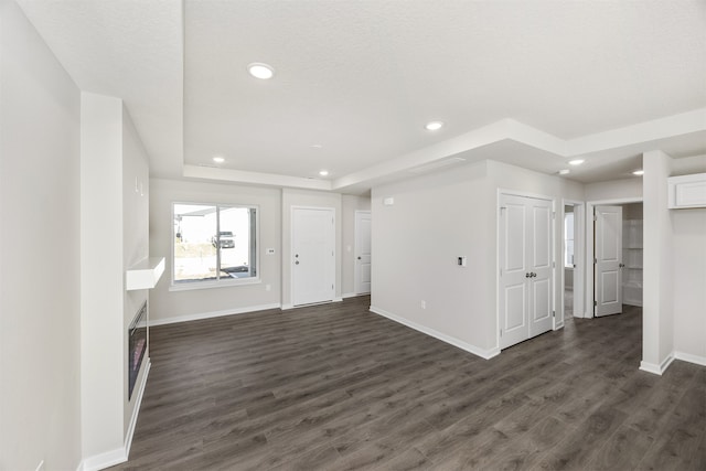 unfurnished living room with dark wood-type flooring and a textured ceiling