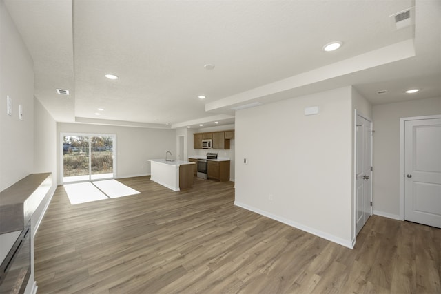 unfurnished living room with sink and light wood-type flooring