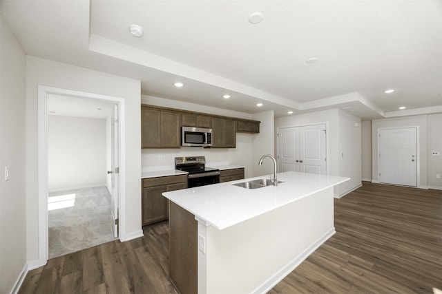 kitchen featuring an island with sink, dark hardwood / wood-style floors, sink, and appliances with stainless steel finishes