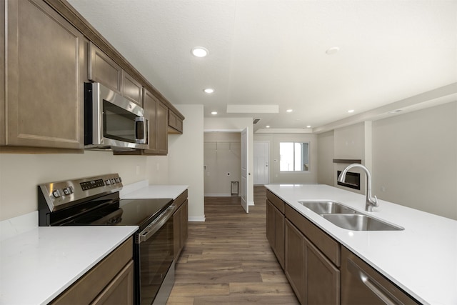 kitchen featuring hardwood / wood-style flooring, dark brown cabinets, sink, and appliances with stainless steel finishes