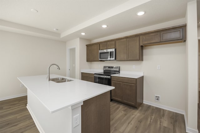 kitchen featuring hardwood / wood-style floors, sink, a center island with sink, and stainless steel appliances