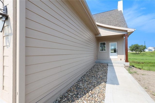 1773 Highland Cir SW, Altoona, IA 50009 - entrance to property featuring roof with shingles and a chimney