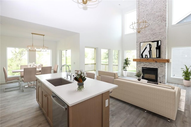 1773 Highland Cir SW, Altoona, IA 50009 - kitchen featuring a chandelier, stainless steel dishwasher, a sink, a high ceiling, and light countertops