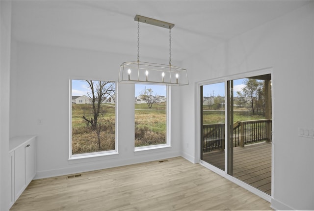 1773 Highland Cir SW, Altoona, IA 50009 - unfurnished dining area featuring wood finished floors, a chandelier, and baseboards