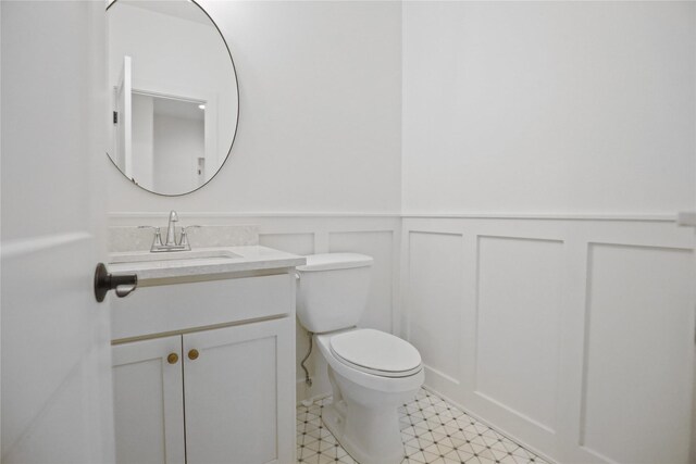 1773 Highland Cir SW, Altoona, IA 50009 - half bath featuring vanity, wainscoting, toilet, and a decorative wall