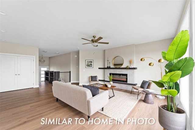 living room featuring hardwood / wood-style floors, ceiling fan, and a premium fireplace