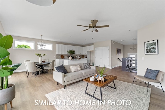 living room featuring ceiling fan and light hardwood / wood-style floors