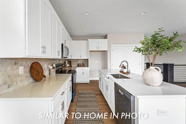 kitchen with sink, dark hardwood / wood-style floors, a kitchen island with sink, white cabinets, and black appliances