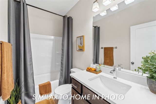 full bathroom with shower / tub combo with curtain, vanity, and toilet