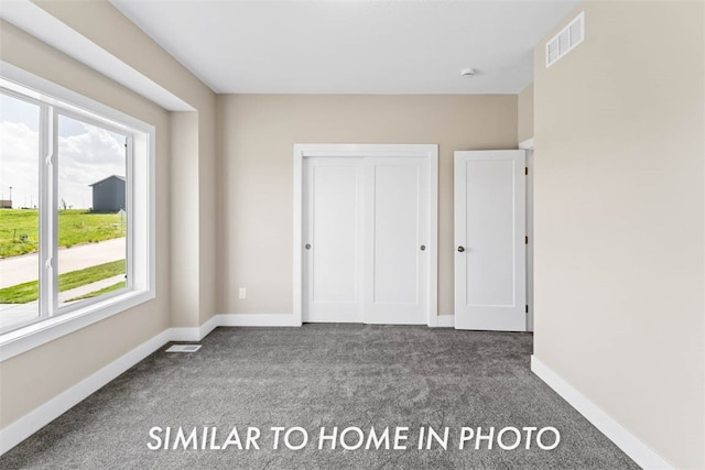 unfurnished bedroom featuring dark colored carpet