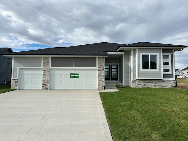 prairie-style home featuring a garage and a front lawn