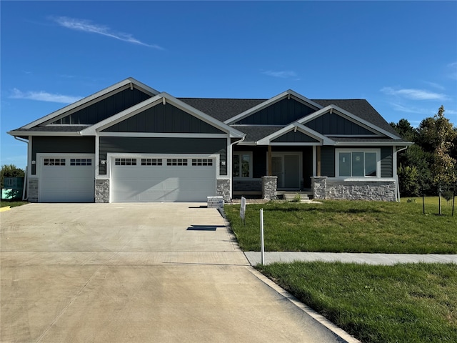 craftsman inspired home featuring a front yard and a garage