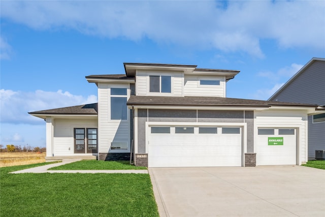 prairie-style home with a front yard, central AC, and a garage