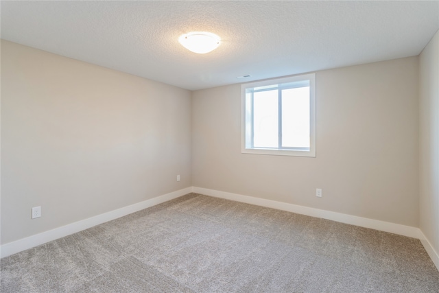 empty room with a textured ceiling and carpet