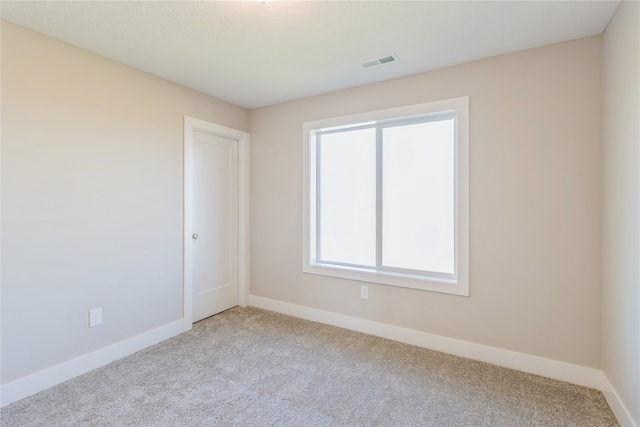 spare room featuring light colored carpet