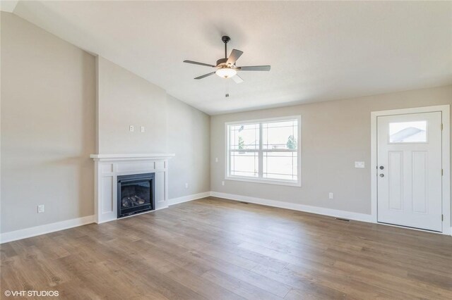 unfurnished living room with ceiling fan, hardwood / wood-style flooring, and lofted ceiling