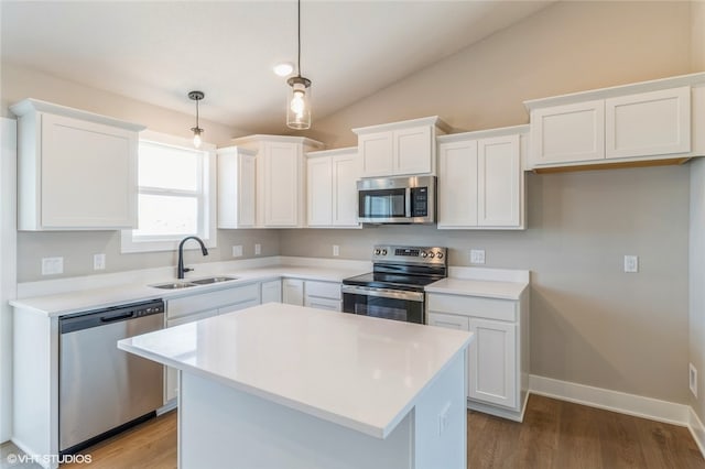 kitchen with a kitchen island, hanging light fixtures, stainless steel appliances, sink, and white cabinets