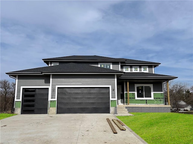 prairie-style home with a front yard and a garage