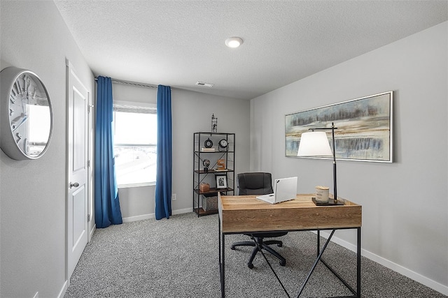 office area with a textured ceiling, carpet floors, visible vents, and baseboards